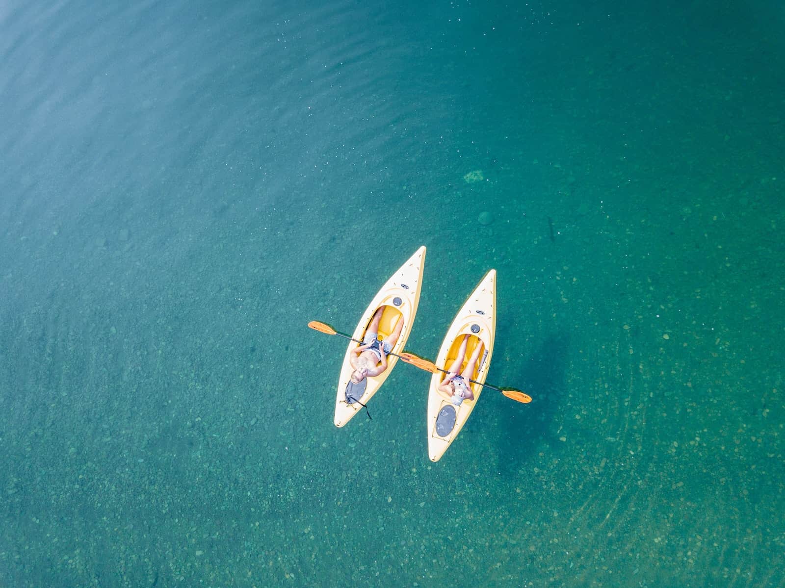 Bird's Eye View of Two People Kayaking on Body of Water