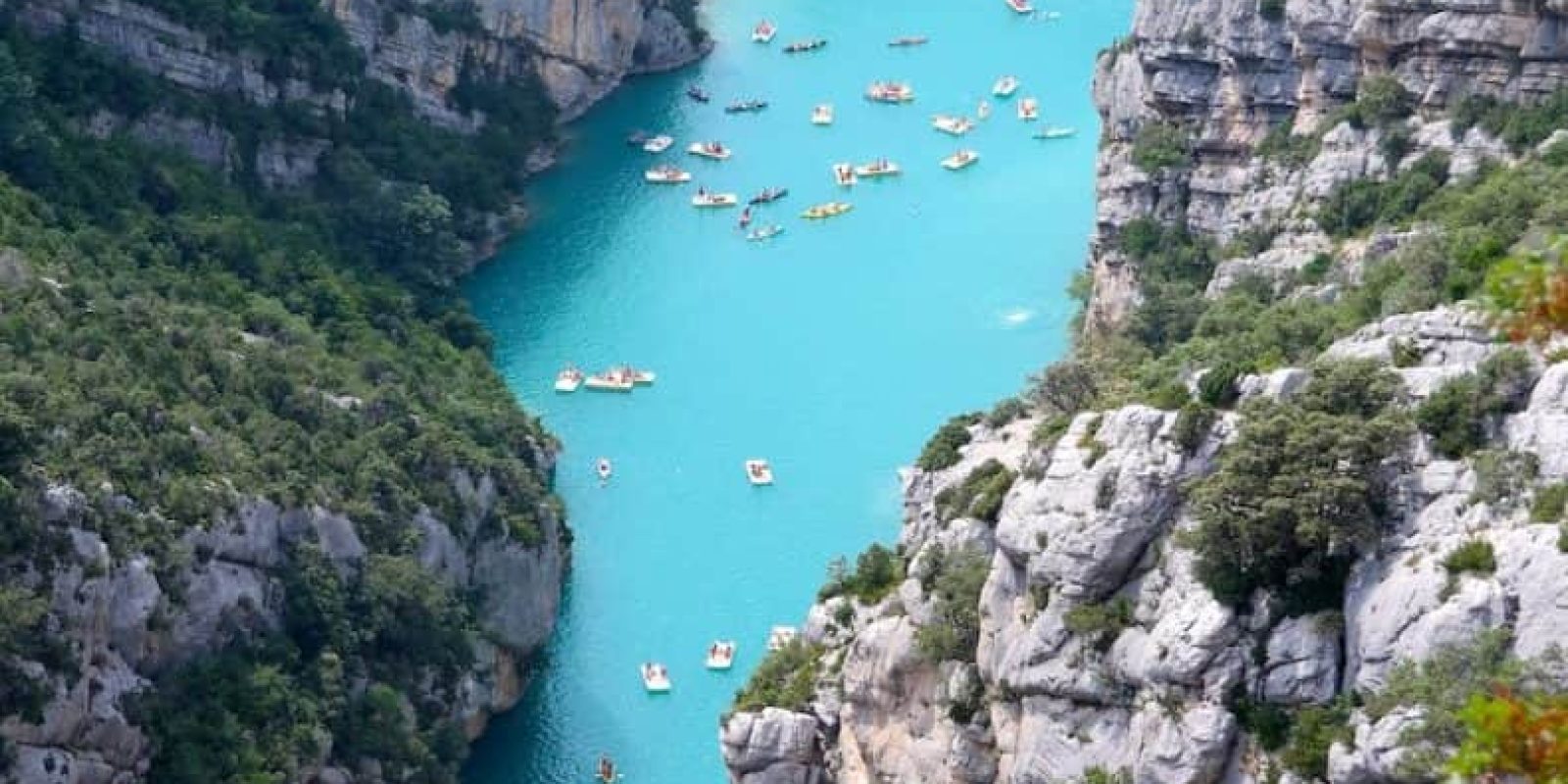 aerial view of boats on body of water beside mountain