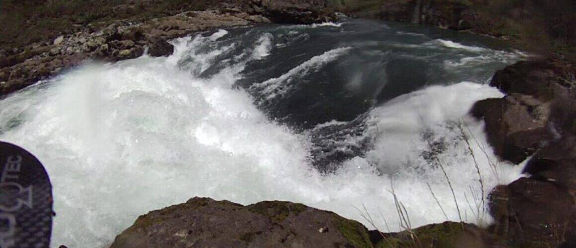 Kayaker navigating whitewater rapids on river
