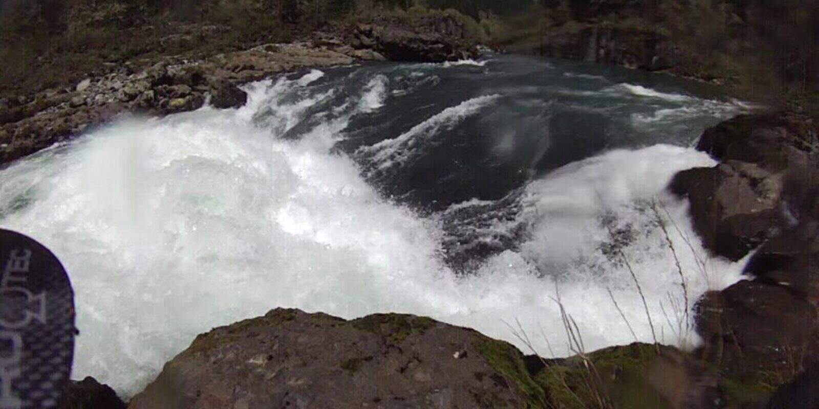 Kayaker navigating whitewater rapids on river
